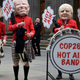 Oxfam activists dressed as a Scottish pipe band and representing (L-R) French President Emmanuel Macron, US President Joe Biden and British Prime Minister Boris Johnson during their “Big Heads” protest at the Royal Exchange Square in Glasgow on November 1, 2021 on the sidelines of the COP26 UN Climate Summit.